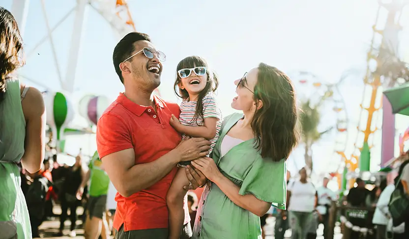 Familia sonriente en una feria gracias a  un préstamo de nómina que les permitió disfrutar momentos inolvidables.